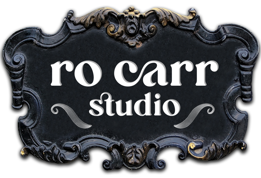 Ro Carr Studio Logo on a baroque style plaque.