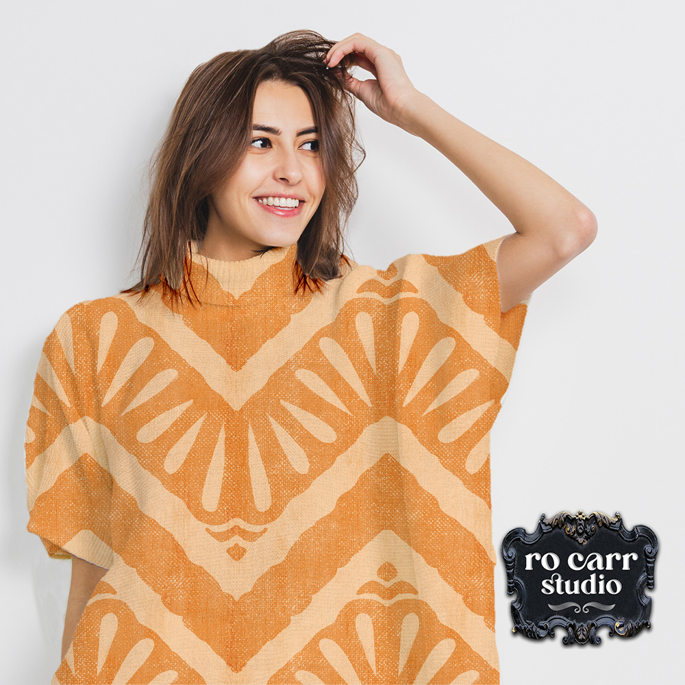Attractive caucasian woman with shoulder length dark hair wearing a short sleeve knit poncho featuring the "Moroccan Zig Zag" pattern