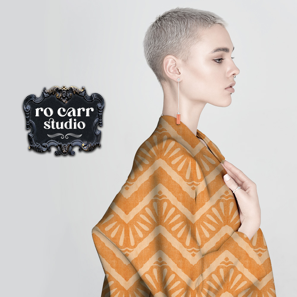 Slender caucasian female model with very short blond hair wearing a loose fitting overcoat featuring the "Moroccan Zig Zag" pattern