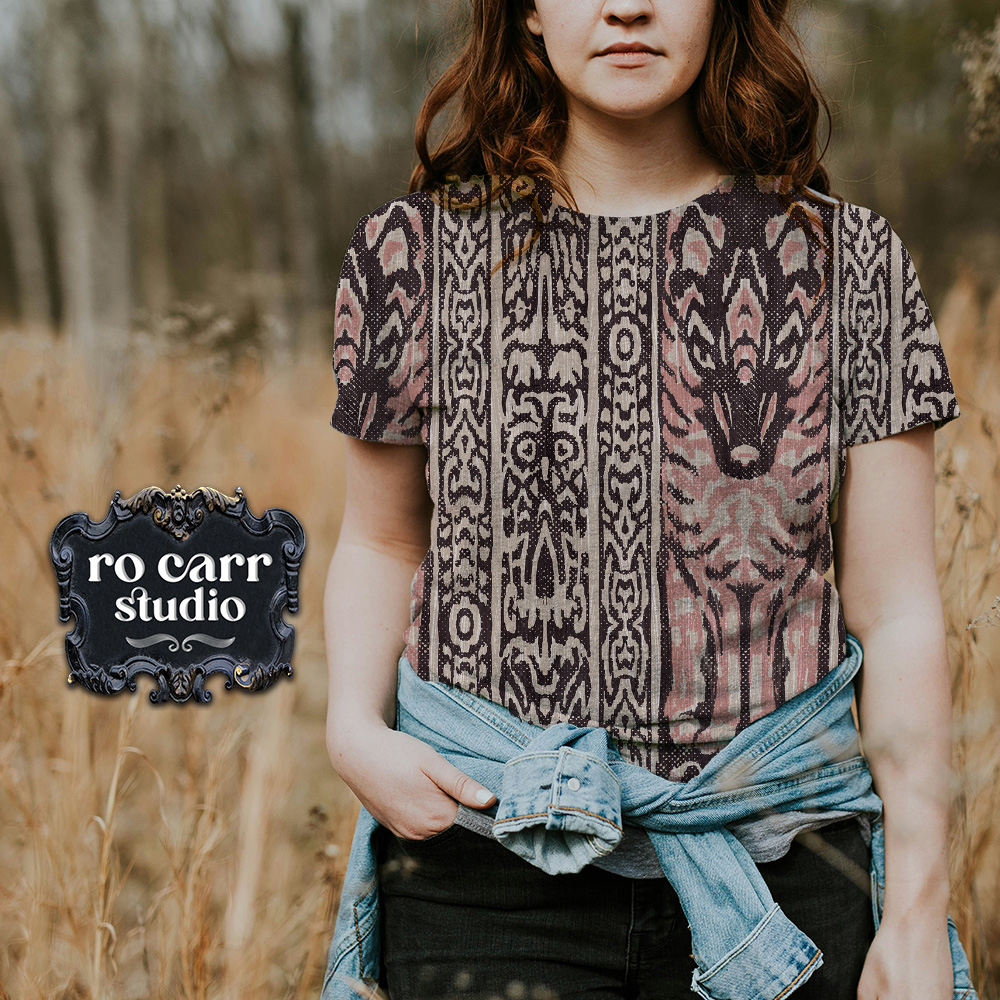 Woman standing in a meadow wearing a tee printed with the Owl & Lupo design.