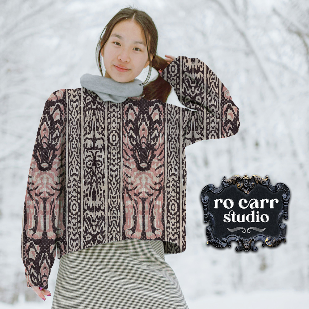 Woman in snowy scene wearing sweatshirt featuring the Lupo & Owl design.