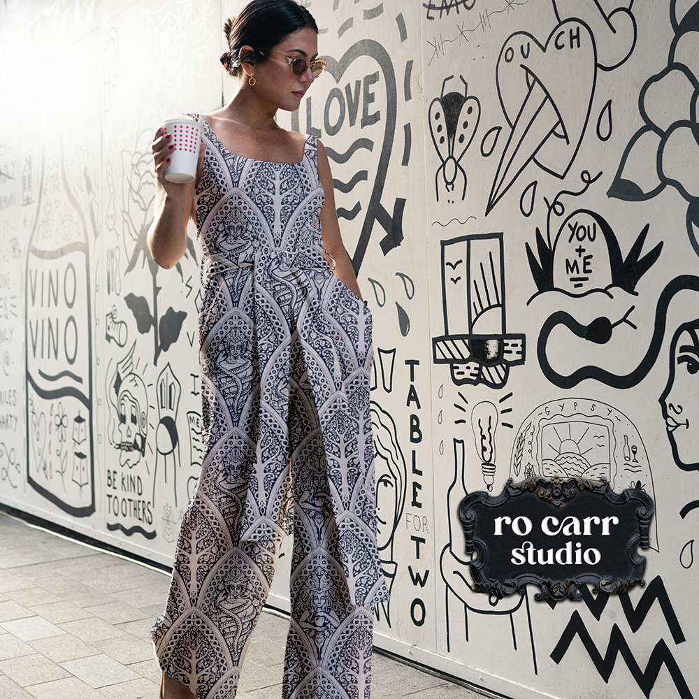 Mockup of woman wearing a fabric jumpsuit printed with A Gothic Love Story pattern.