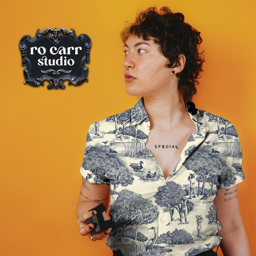 Toile de Jouy pattern with a birdwatching theme, mocked up as a button up collared shirt worn by a woman with many tattoos.