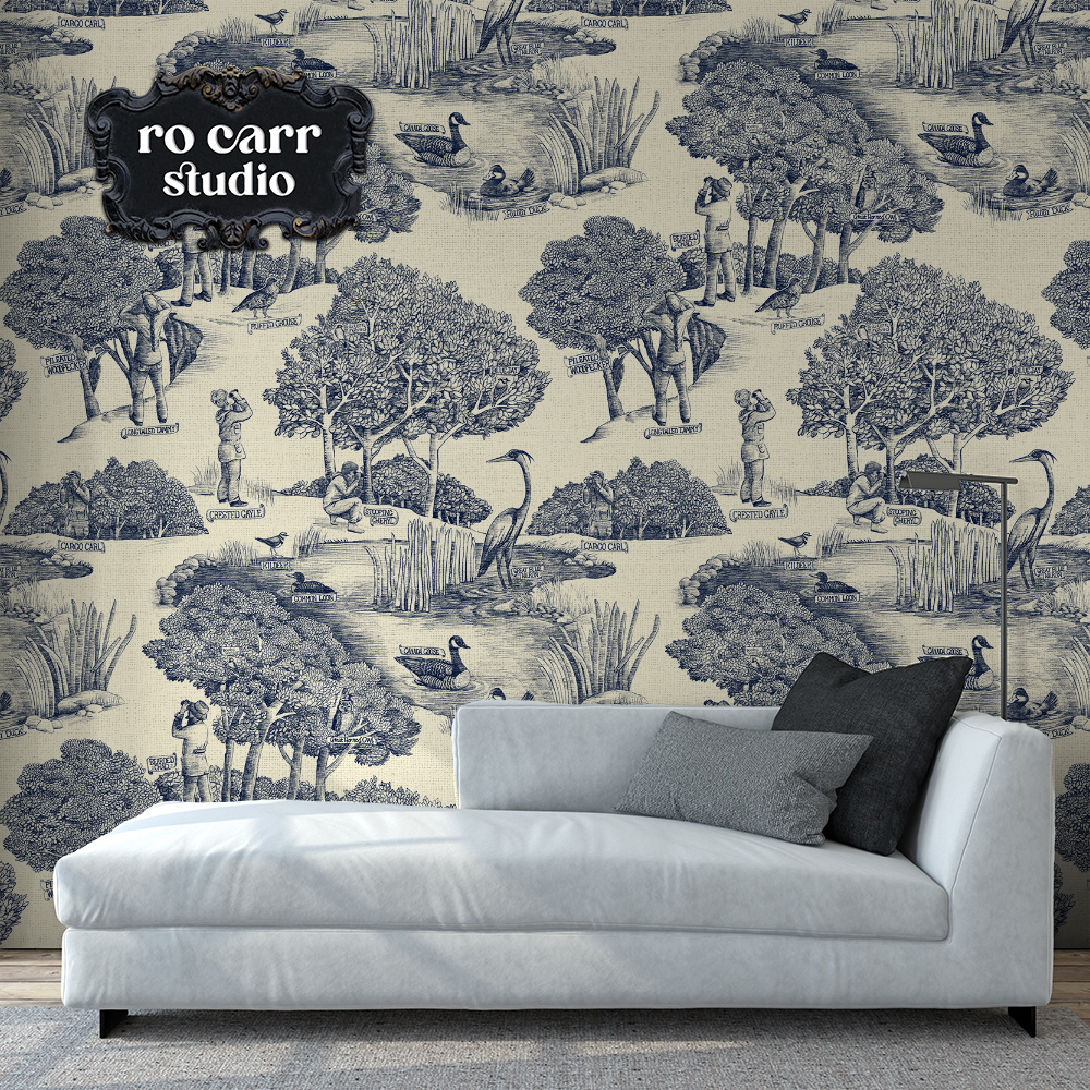 Toile de Jouy pattern with a birdwatching theme, shown in this mockup as wallpaper in a modern room behind a chaise lounge.