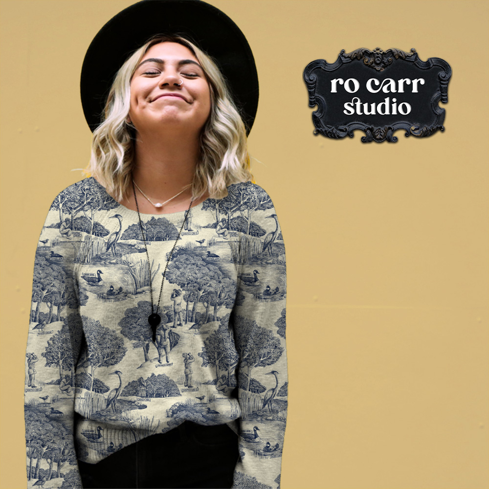 Toile de Jouy pattern with a birdwatching theme, mocked up as a soft sweater worn by a young woman in a hat.