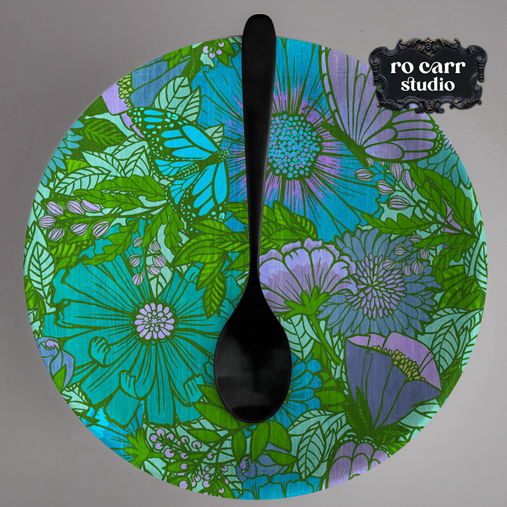 Electric floral pattern printed on a dinner plate, shown with a black spoon.