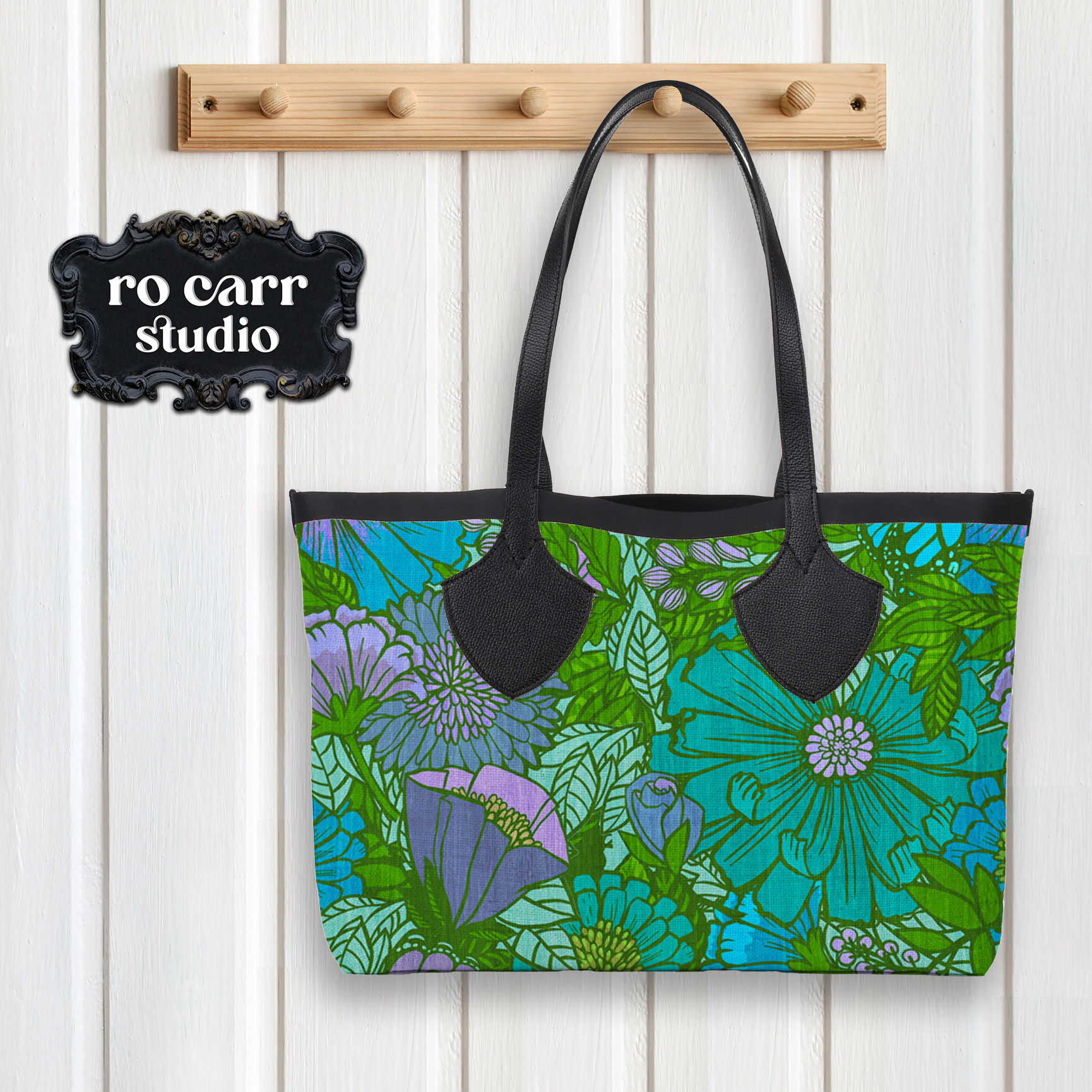 Tote bag with black straps hanging on a wall hook, printed with the electric floral pattern.