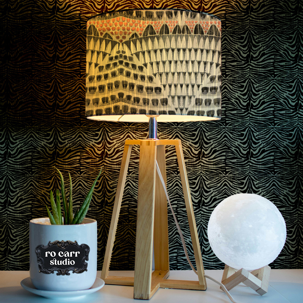 Vignette of a side table displaying a fabric lamp shade mocked up with the armadillo pattern.