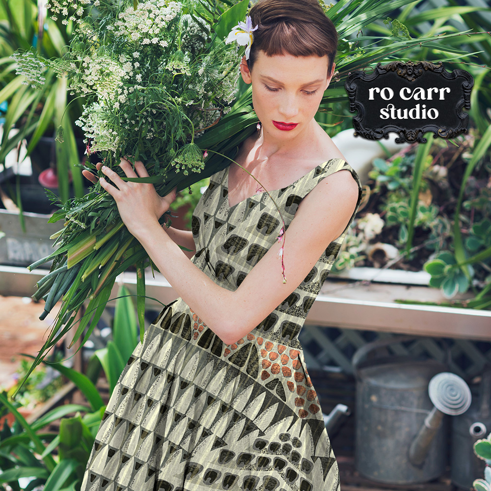 Woman working in a garden wearing a sleeveless dress printed with the Armadillo pattern.