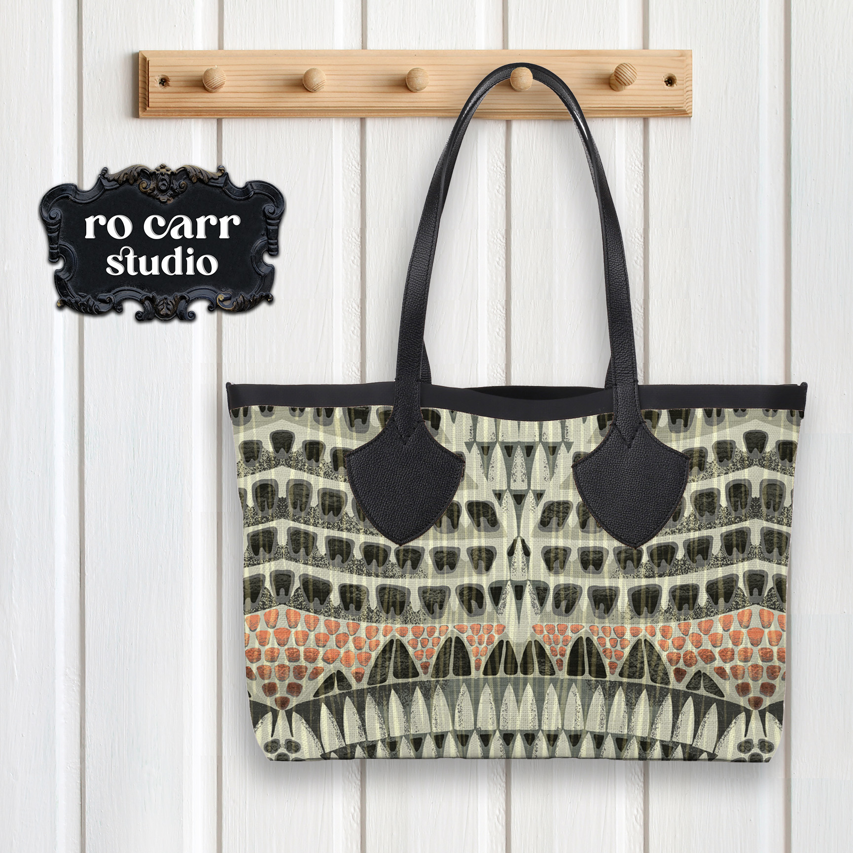 Leather and fabric tote bag hanging from a peg, printed with the Armadillo pattern.