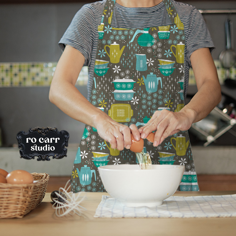 Woman working in a kitchen wearing an apron made with the pattern in teal.