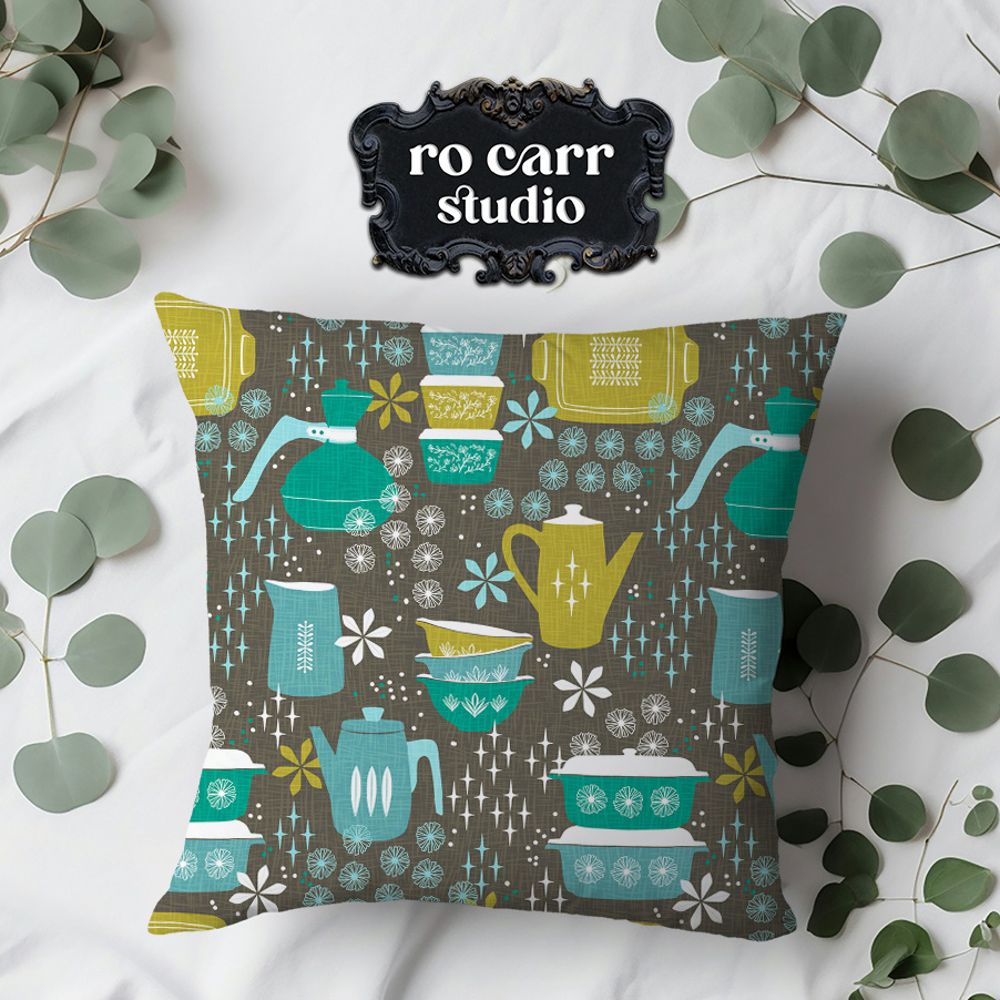 Throw pillow made of fabric printed with the pattern, shown with a surface strewn with eucalyptus leaves.