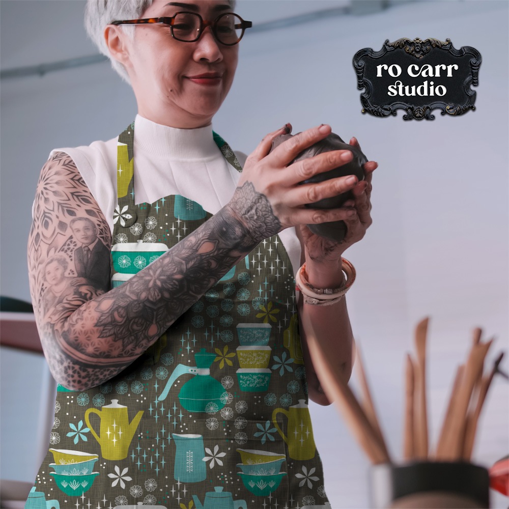 Woman potter at work, wearing an apron made with the pattern in teal.