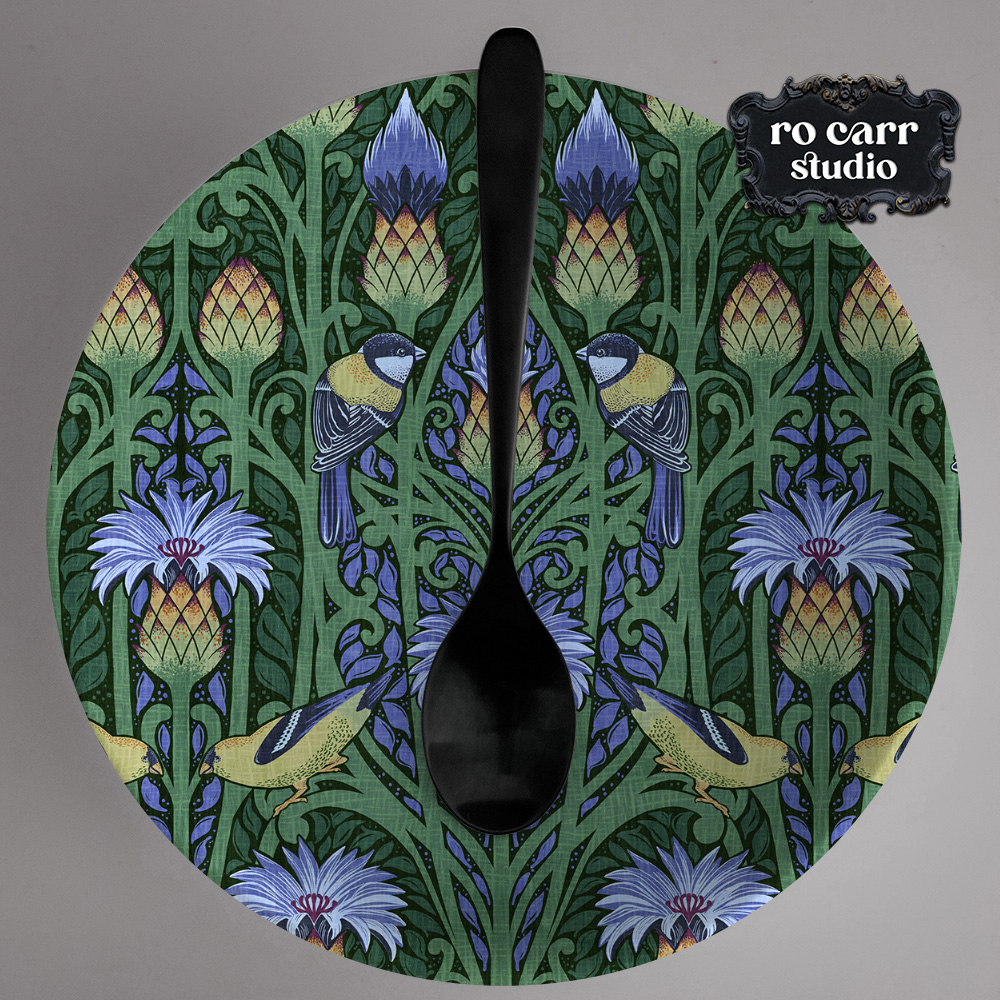 Nouveau blue pattern printed on a serving dish with a black spoon centered vertically.