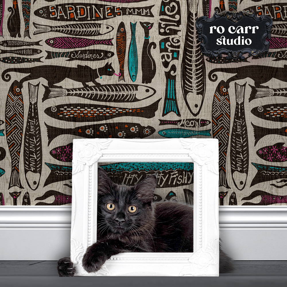 Wallpaper mockup displaying "Catch of the Day" design, with a small black kitten in a white frame in the foreground.