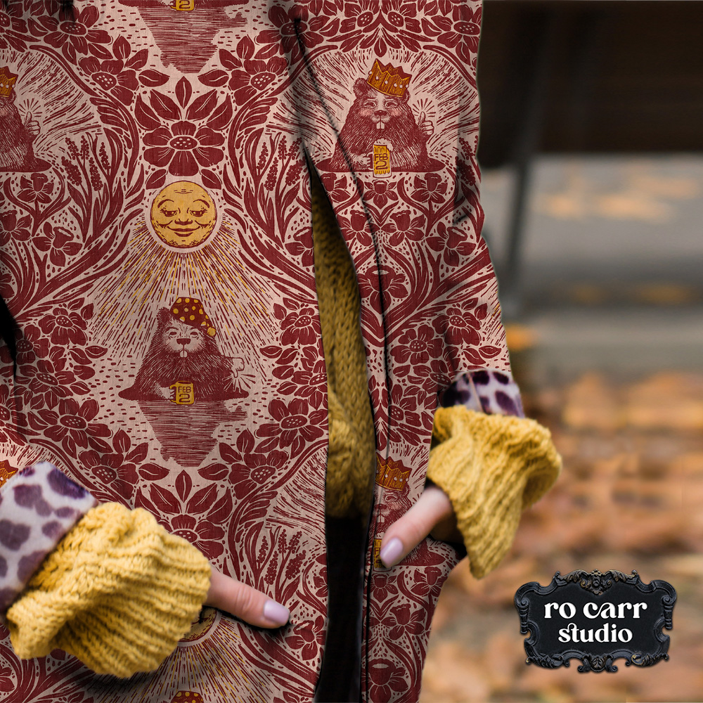 Mockup of woman wearing an overcoat in the rose gold colorway of the Groundhog Day Damask design.