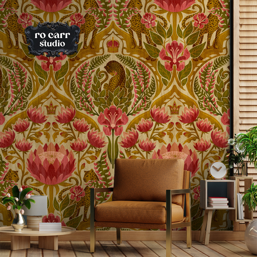 A damask leopard and tropical floral pattern in antique gold, olive green, and rose red shown as wallpaper in a warm-toned living space with a tan sofa.