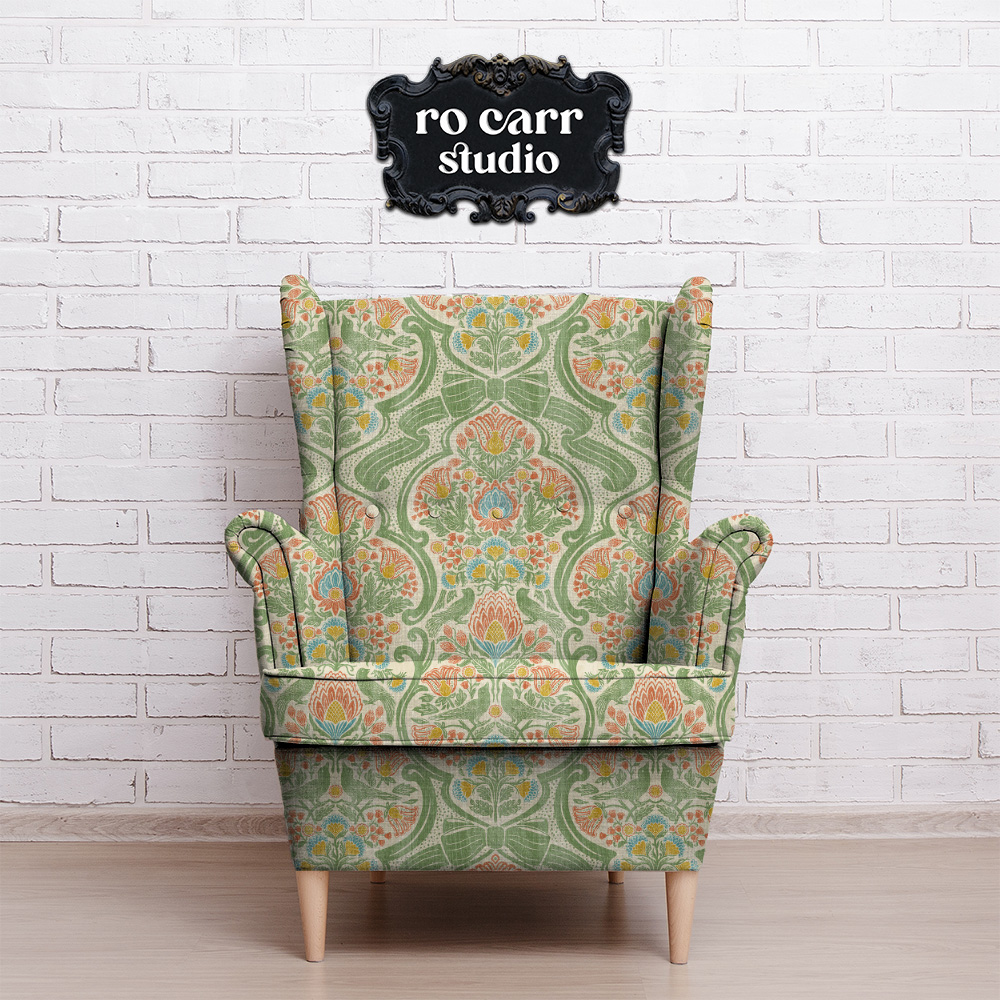 Wingback armchair upholstered in a botanical chintz print, shown against a white brick wall.