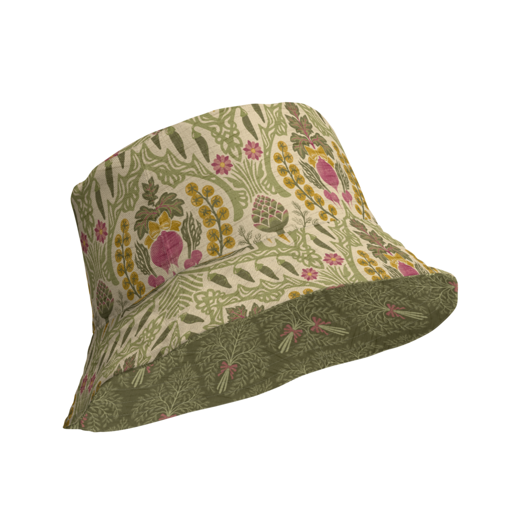Reversible bucket hat with Heirloom and Bloom pattern featuring hand-drawn artichokes, beets, and wildflowers on a cream ground