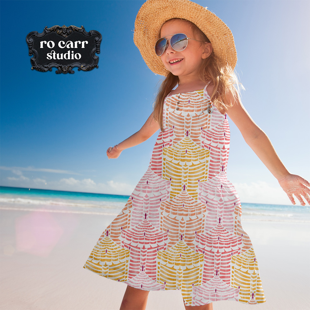 Young girl in a full-skirted Cabana Republic dress, spinning on a sunny beach.