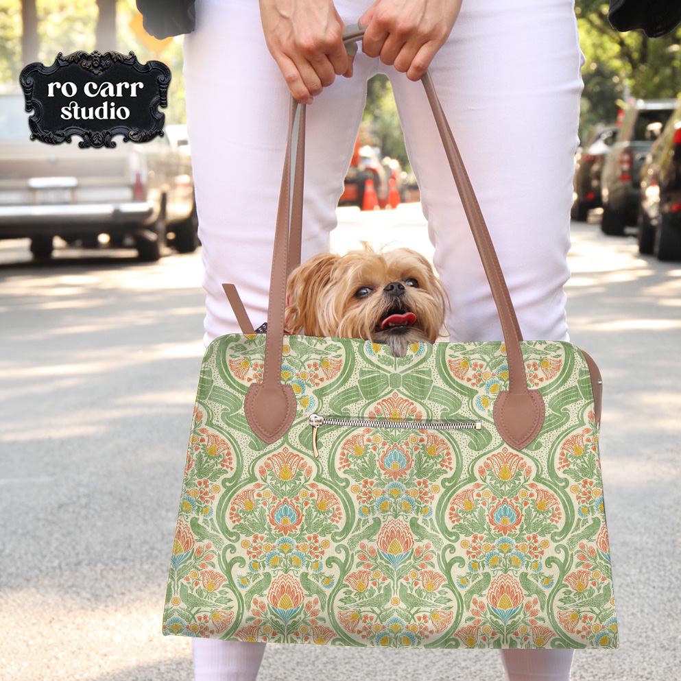 Person carrying a large tote bag in a botanical chintz print, small dog peering over the top.