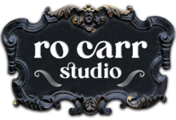 Ro Carr Studio Logo on a baroque style plaque.