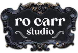 Ro Carr Studio Logo on a baroque style plaque.